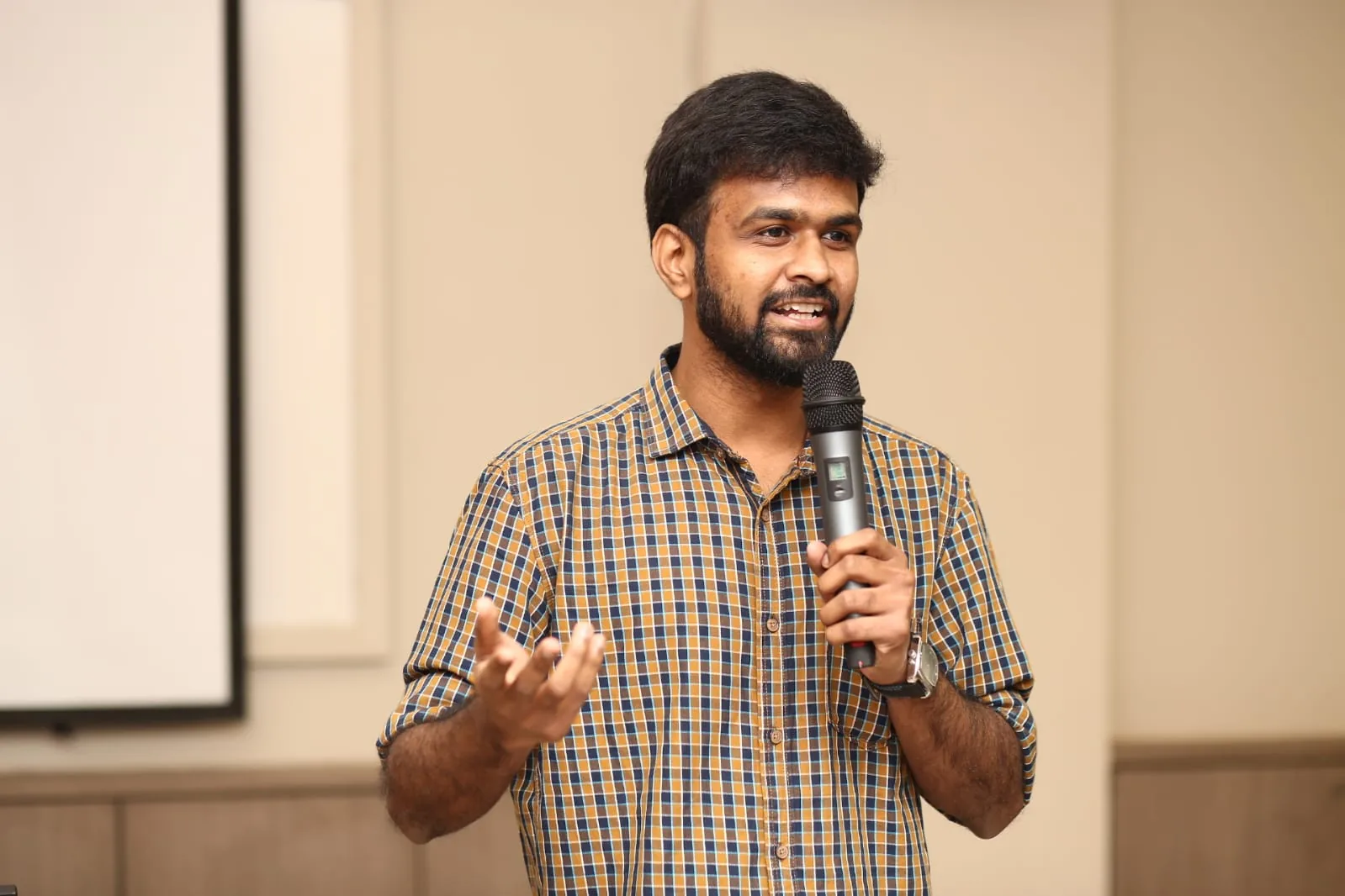 Akshay Shaligram speaking with a microphone